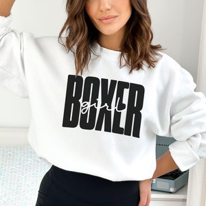 May include: White sweatshirt with black text that reads "BOXER girl".