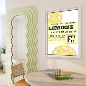Puede incluir: Un póster enmarcado blanco con fondo amarillo y un gráfico de limones. El texto en el póster dice "You said I must eat so many lemons cause' I am so bitter. I said I'd rather be with your friends mate cause' they are much fitter."