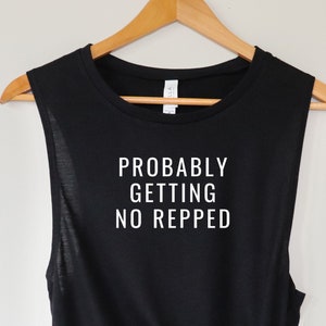 Op de afbeelding: Zwart tanktop zonder mouwen met de tekst "Probably Getting No Repped" in wit.