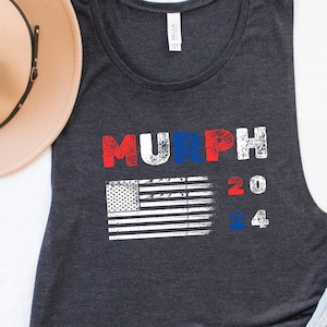 May include: A dark heather gray sleeveless tank top with a distressed American flag and the text "MURPH 2024" in red, white, and blue.