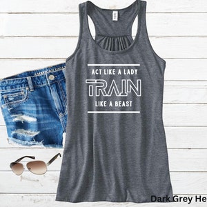 May include: Dark grey heather tank top with white text that reads "Act like a lady, train like a beast".