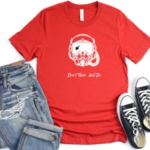 May include: Red t-shirt with a white graphic of a pilot's helmet and the text "Don't Think, Just Do."