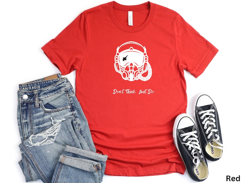 May include: Red t-shirt with a white graphic of a pilot's helmet and the text "Don't Think, Just Do."