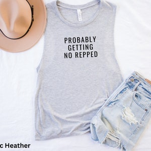 Op de afbeelding: Grijs sleeveless muscle tank top met de tekst "PROBABLY GETTING NO REPPED" in zwart.