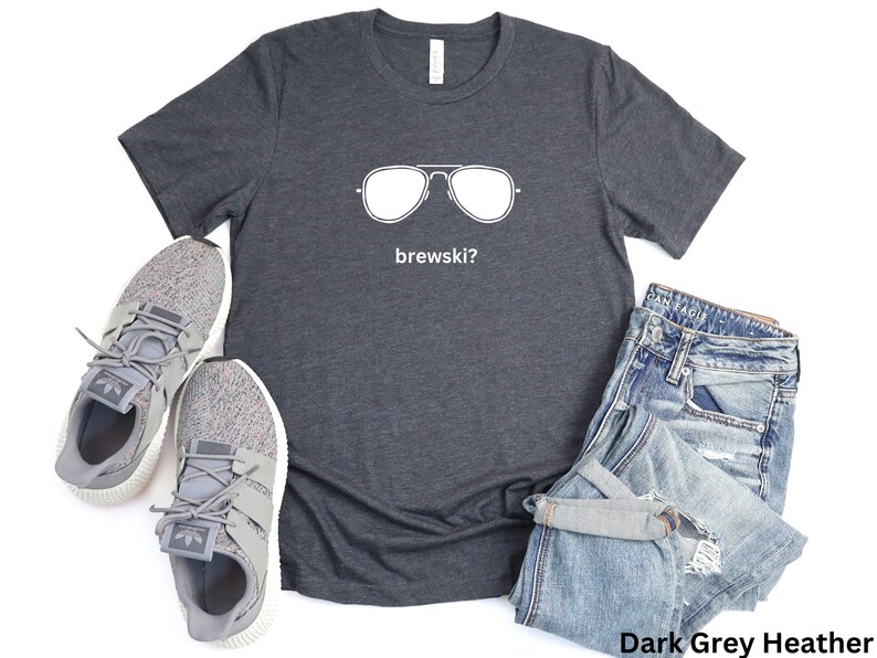Puede incluir: Camiseta de color gris oscuro jaspeado con un gr&aacute;fico blanco de gafas de sol y el texto "brewskis?"