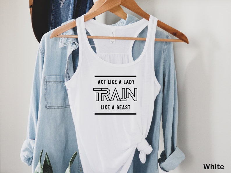 May include: White tank top with the text "Act like a lady train like a beast" in black lettering.