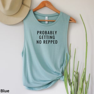 Op de afbeelding: Stofkleurig blauw tanktop zonder mouwen met de tekst "Probably Getting No Repped" in zwart gedrukt.