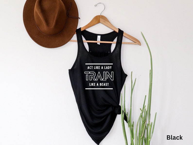 May include: Black tank top with the text "Act like a lady, train like a beast" in white lettering.