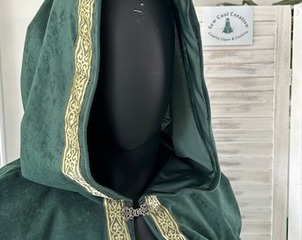 May include: A dark green hooded cape with gold trim and a decorative clasp. The cape is made of a soft, velvety fabric.