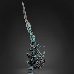 May include: A vertical mineral specimen featuring elongated, sharp, teal-green crystalline structures with copper-toned accents. The cluster displays a jagged, blade-like formation with smaller, dense crystal growths at the base and the text Xeptional Art.