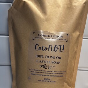 May include: A brown pouch with a white spout, filled with a clear liquid. The pouch has a label that reads "Coconot! 100% Olive Oil Castile Soap Sixteen Ounces 42 oz. To use: Dispense small amount onto hands, wash cloth or bath puff. Lather up and rinse well. Ingredients: Olea Europaea (Olive) Fruit Oil, Water Potassium Hydroxide Goshen, IN GoshenLotion.com"