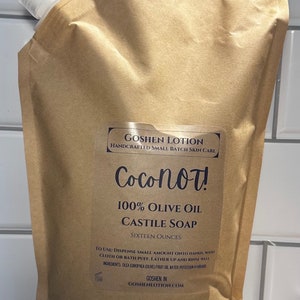 May include: A brown pouch with a white spout, containing Coconot! 100% Olive Oil Castile Soap. The pouch is labeled with the brand name, product name, and ingredients. It is 16 ounces.