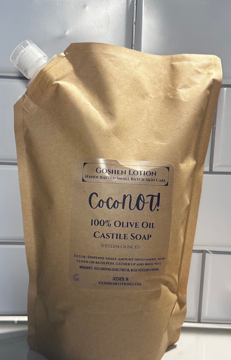 May include: A brown pouch with a white spout, containing Coconot! 100% Olive Oil Castile Soap. The pouch is labeled with the brand name, product name, and ingredients. It is 16 ounces.