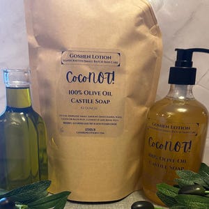 May include: A brown paper bag with a label that reads "Goshen Lotion Handcrafted Small Batch Skin Care Coconot! 100% Olive Oil Castile Soap 42 ounces" and a clear bottle with a pump dispenser that reads "Goshen Lotion Handcrafted Small Batch Skin Care Coconot! 100% Olive Oil Castile Soap".