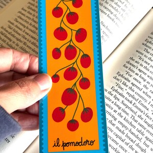 May include: A turquoise and orange bookmark with a red tomato vine illustration. The bookmark has the text "10&cent;" and "il pomodoro" printed on it.