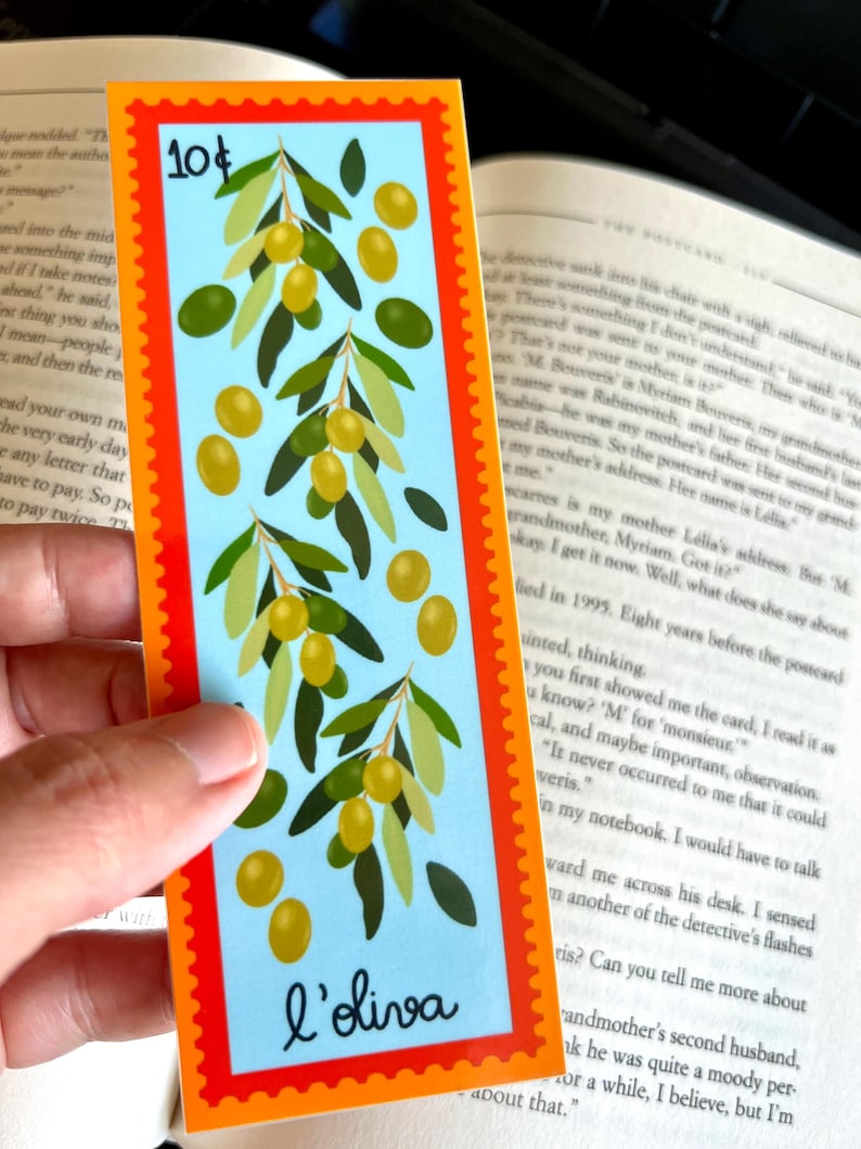 May include: A blue and orange bookmark with a design of olive branches and olives. The bookmark has the text "10&cent;" and "l'oliva" printed on it.