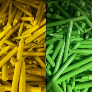 May include: A close-up image of two bundles of crayons. One bundle is yellow and the other is green. The crayons are arranged in a random pattern.