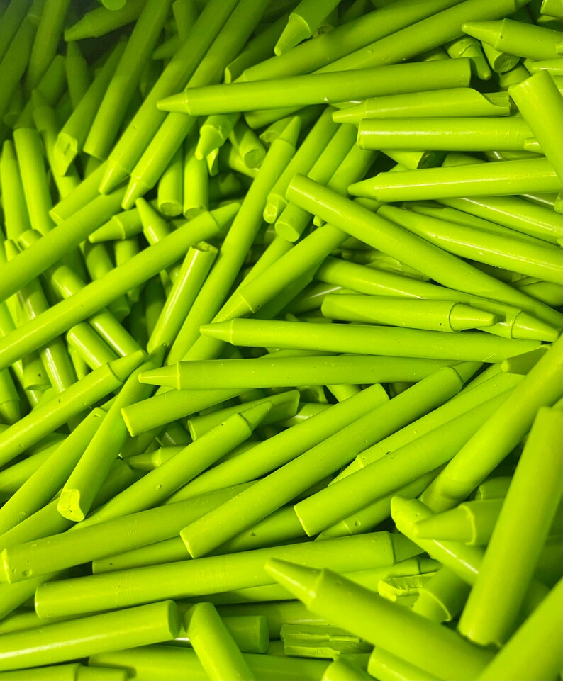 May include: A large pile of bright green crayons. The crayons are all the same size and shape, and they are arranged in a random pattern.