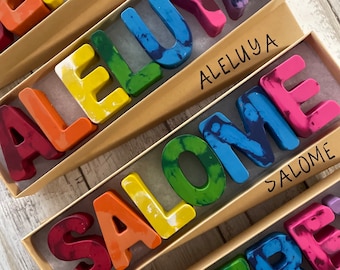 May include: A set of five personalized boxes containing colorful, hand-painted crayon letters spelling out the names "BENITO", "ALELUYA", "SALOME", and "JEFFREY".