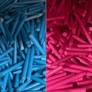 May include: A close-up image of a large pile of blue and pink crayons. The crayons are arranged in a random pattern, with some of the crayons sticking out from the pile.