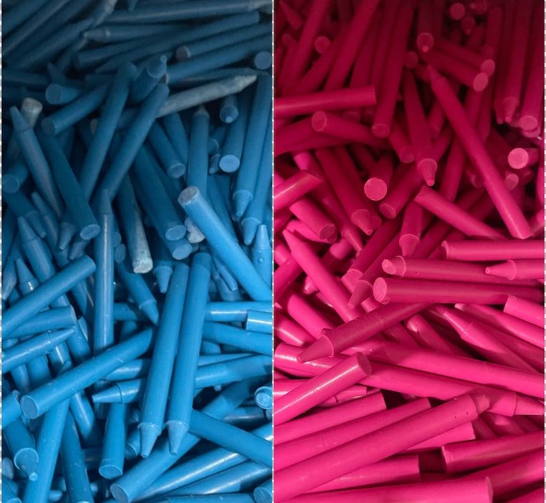 May include: A close-up image of a large pile of blue and pink crayons. The crayons are arranged in a random pattern, with some of the crayons sticking out from the pile.