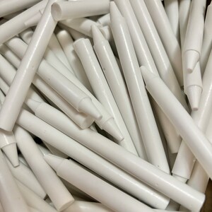 May include: A pile of white chalk sticks, arranged in a random pattern. The sticks are all the same size and shape, and they are all made of white chalk.