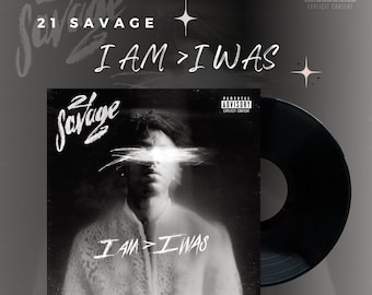 Può includere: Una copertina di album in bianco e nero con un ritratto di un uomo con il viso sfocato. La copertina dell'album ha il testo "21 Savage" e "I AM > I WAS". La copertina dell'album è circondata da un disco in vinile nero.