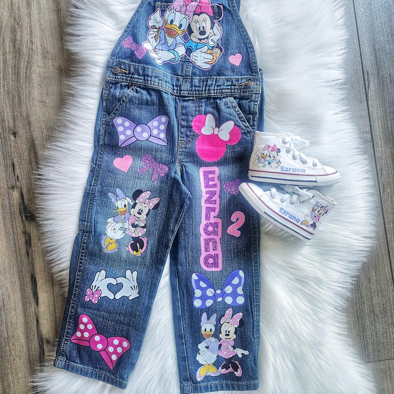 Mono de Daisy Duck y Minnie Mouse. Conjunto de mezclilla con lazo de Minnie. Zapatillas Converse a juego disponibles. imagen 1