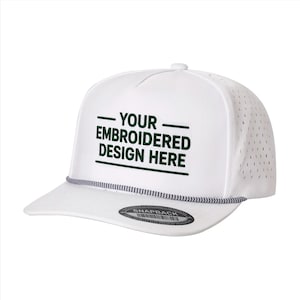 May include: A white snapback cap featuring a perforated side panel and a dark blue and white braided cord across the brim. The front displays the dark green embroidered text "YOUR EMBROIDERED DESIGN HERE" between two horizontal lines.