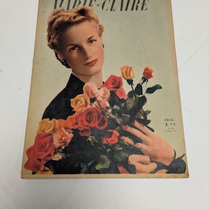 Peut inclure: Couverture vintage du magazine Marie Claire avec une femme tenant un bouquet de roses rouges, roses et jaunes. Le titre du magazine "Marie Claire" est écrit en caractères sérif.