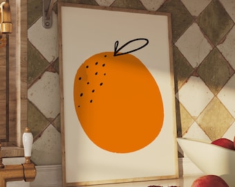 May include: A kitchen with a white countertop and a gold faucet. A framed print of an orange with a black stem hangs on the wall above the countertop. A bowl of red pomegranates sits on the countertop.