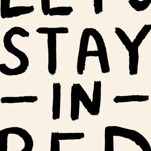 May include: Black and white text art print with the words "Let's Stay In Bed".