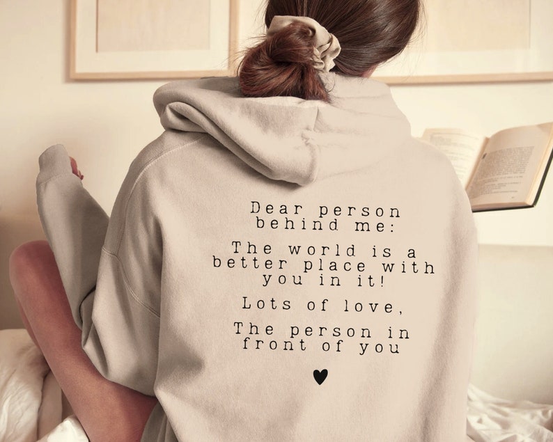 May include: A light gray hoodie with a message printed on the back: "Dear person behind me: The world is a better place with you in it! Lots of love, The person in front of you".