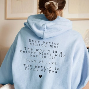 May include: Light blue hooded sweatshirt with a message printed on the back: "Dear person behind me: The world is a better place with you in it! Lots of love, The person in front of you".
