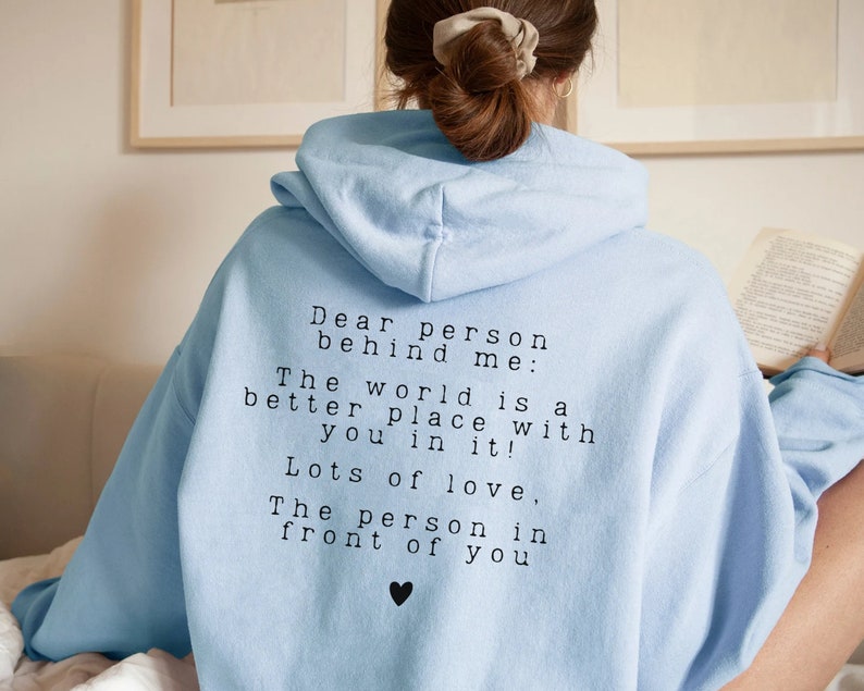 May include: Light blue hooded sweatshirt with a message printed on the back: "Dear person behind me: The world is a better place with you in it! Lots of love, The person in front of you".