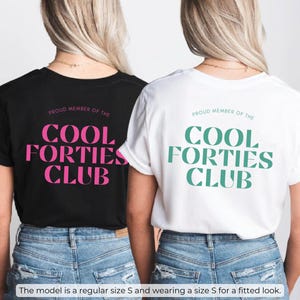 May include: Two black and white t-shirts with the text "Proud Member of the Cool Forties Club" in pink and teal lettering.