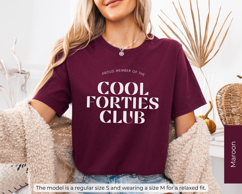 May include: A maroon t-shirt with white text that reads "Proud Member of the Cool Forties Club".
