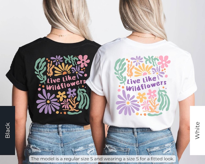 K&ouml;nnte beinhalten: Zwei T-Shirts, eines in Schwarz und eines in Wei&szlig;, mit einem Blumendesign und dem Text "Live Like Wildflowers". Das Design umfasst lila, rosa, gelbe und gr&uuml;ne Blumen und Bl&auml;tter. Die Models tragen die T-Shirts mit blauen Jeans.