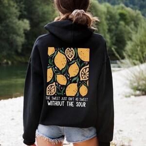 K&ouml;nnte beinhalten: Schwarzer Hoodie mit einem Zitronenprint und dem Text "The sweet just isn't as sweet without the sour".