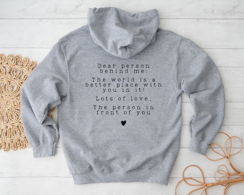 May include: Gray hooded sweatshirt with a message printed on the back: "Dear person behind me: The world is a better place with you in it! Lots of love, The person in front of you".