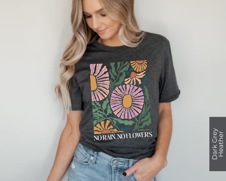 May include: A dark grey heather t-shirt with a floral design and the text "NO RAIN NO FLOWERS".