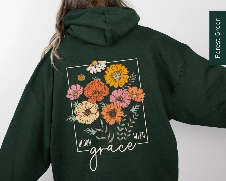 May include: Forest green hooded sweatshirt with a floral design and the text "Bloom with grace" printed on the back.