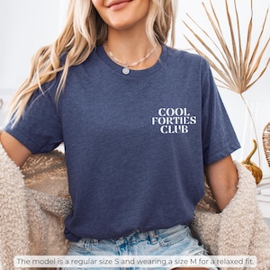 May include: A heather navy blue t-shirt with the text "Cool Forties Club" printed in white on the front.