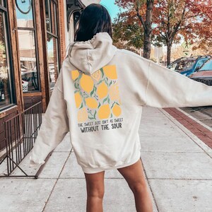 K&ouml;nnte beinhalten: Ein wei&szlig;er Hoodie mit einem Zitronendruck und dem Text "The sweet just isn't as sweet without the sour".