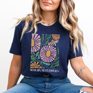 May include: A navy blue t-shirt with a floral graphic and the text "NO RAIN, NO FLOWERS".