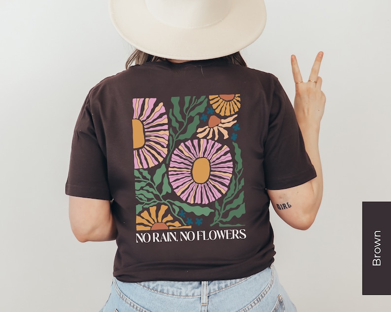 May include: A brown t-shirt with a floral design and the text "NO RAIN, NO FLOWERS".
