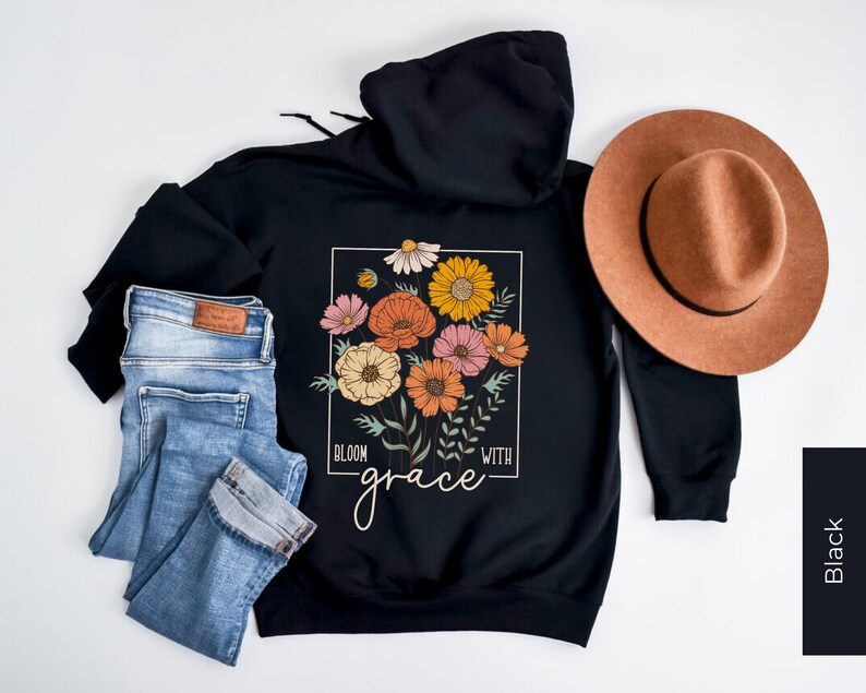 May include: Black hooded sweatshirt with a floral design and the text "Bloom with grace".