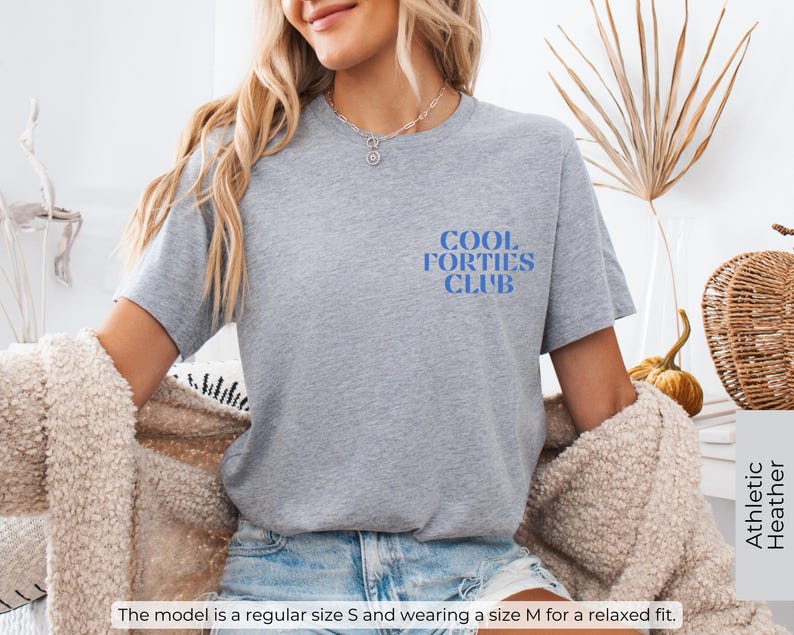 May include: Gray t-shirt with the text "Cool Forties Club" in blue lettering.
