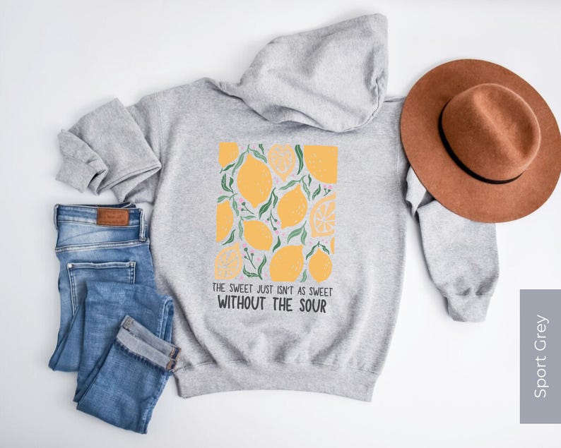 K&ouml;nnte beinhalten: Ein grauer Kapuzenpullover mit einem Zitronendruck und dem Text "The sweet just isn't as sweet without the sour".