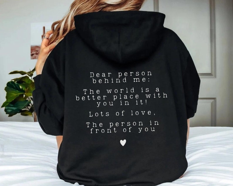 May include: Black hoodie with a white message on the back that reads "Dear person behind me: The world is a better place with you in it! Lots of love, The person in front of you".